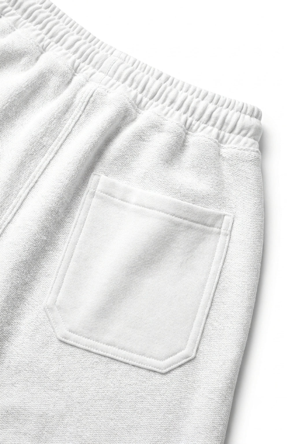 Close-up rear view of the Classic Lounge Lightweight Terry Trousers in Optic White, detailing the patch pocket and fine loopback French terry weave.