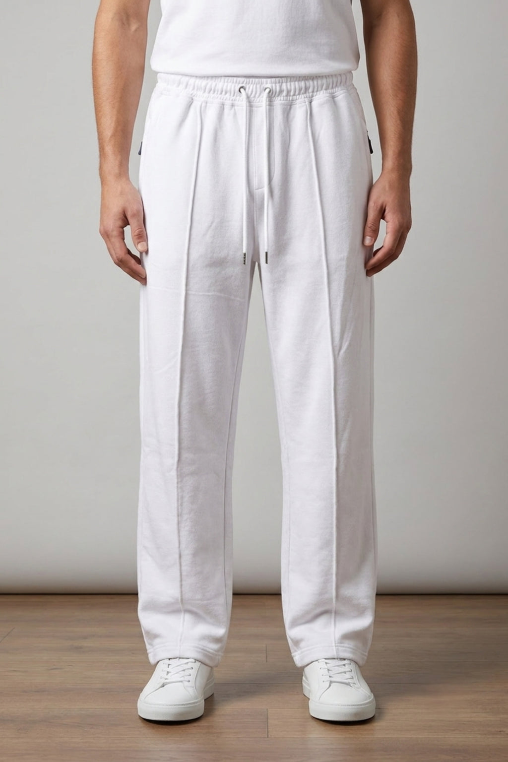 Male model wearing Classic Lounge Lightweight Terry Trousers in Optic White from the waist down, styled with a tucked-in white t-shirt and white sneakers.