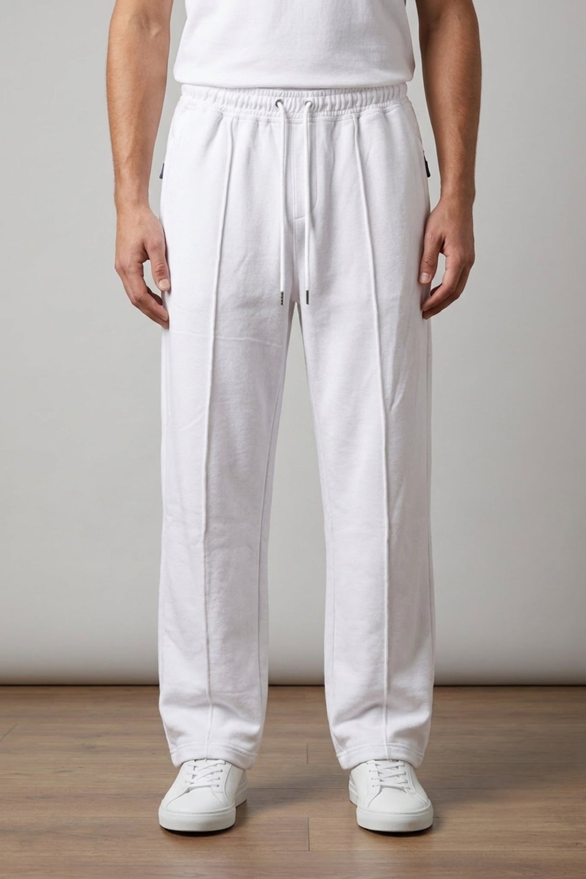 Male model wearing Classic Lounge Lightweight Terry Trousers in Optic White from the waist down, styled with a tucked-in white t-shirt and white sneakers.