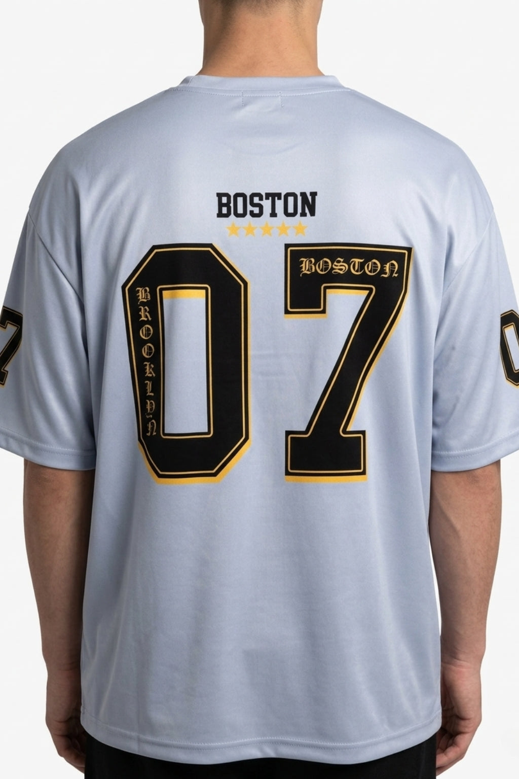Back view of model showing the drop-shoulder drape and large "07" back print of the Coastal Hybrid Jersey.