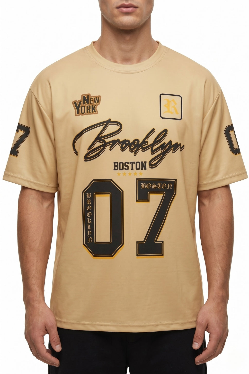 Front view of model wearing The Coastal Hybrid Jersey in Sahara showing oversized fit and chest graphics.