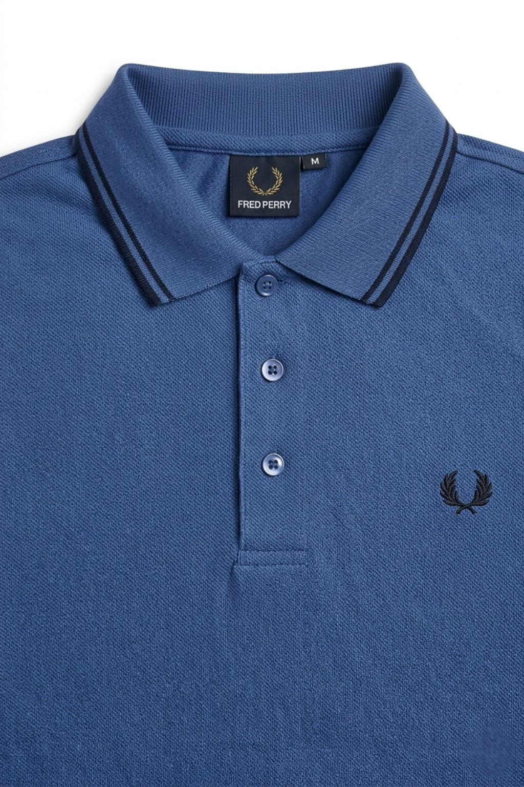 Close-up detail of Eliteez Heritage Twin-Tip Polo - Blue premium pique and embroidered logo.