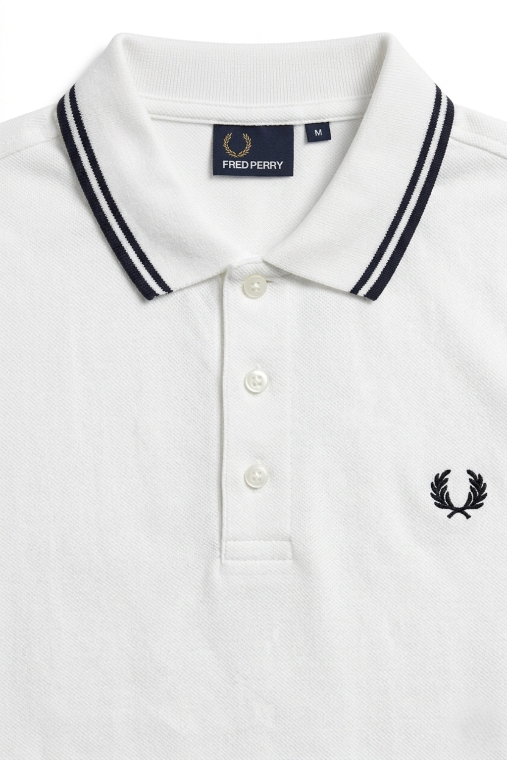Close-up detail of Eliteez Heritage Twin-Tip Polo - White premium pique and embroidered logo.