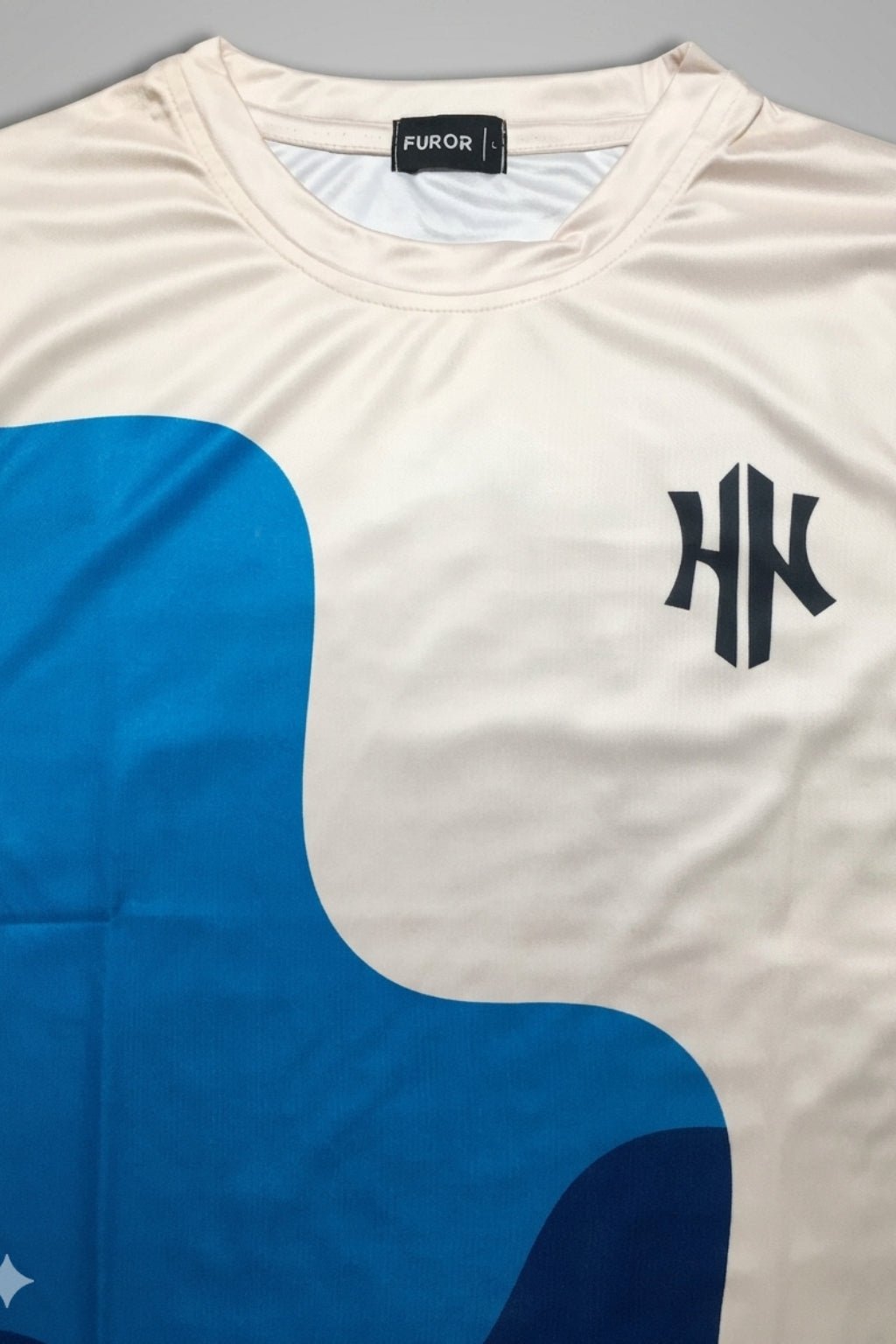 Close-up detail of the Strata Wave print and logo on Athletic Interlock fabric.