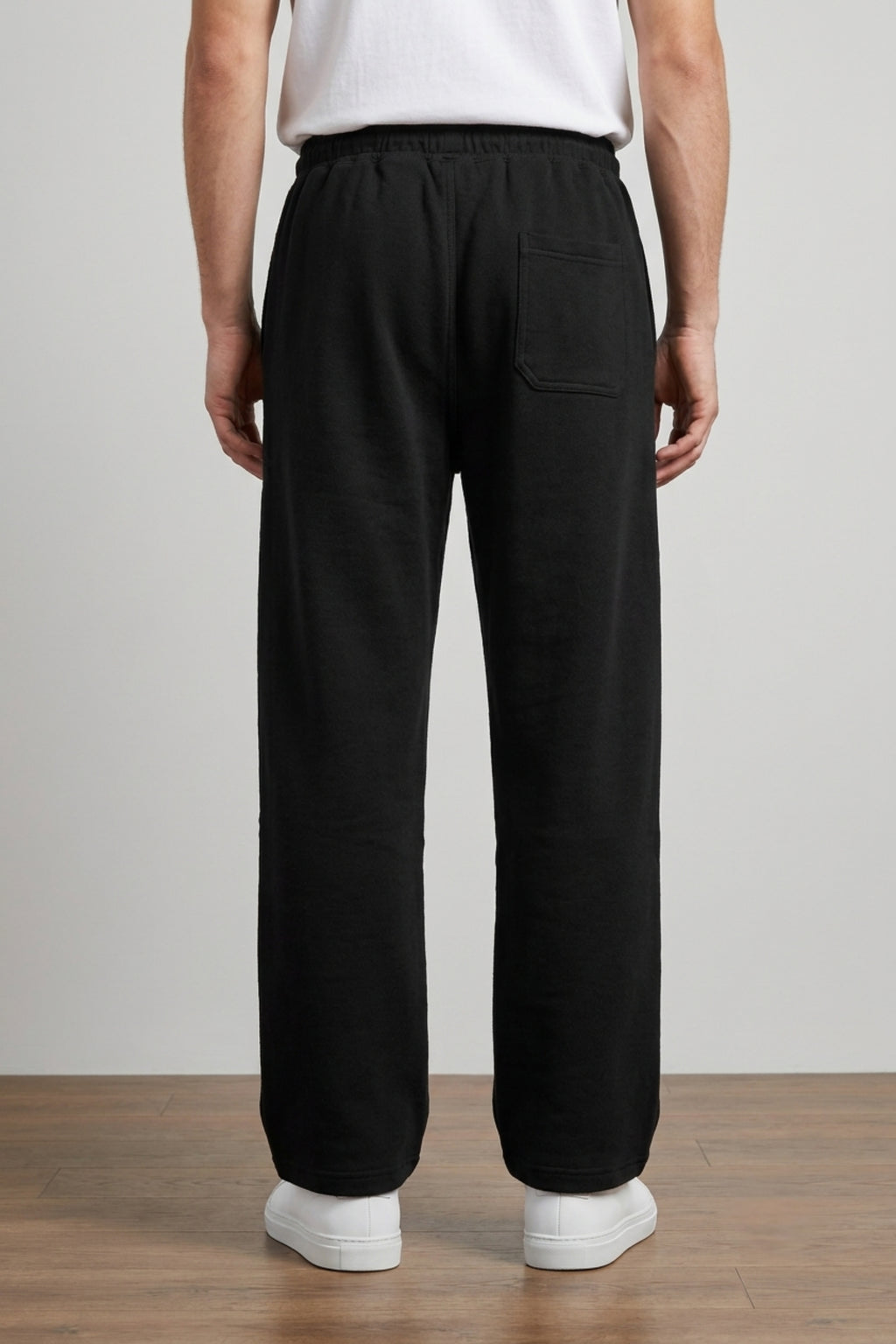 A male model wearing the Deep Black Classic Lounge Lightweight Terry Trousers, viewed from the rear, showcasing the relaxed baggy silhouette.