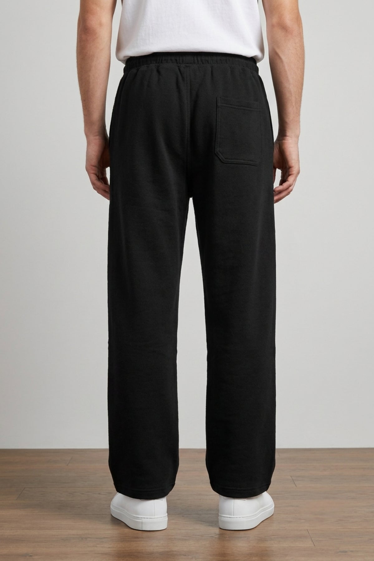 A male model wearing the Deep Black Classic Lounge Lightweight Terry Trousers, viewed from the rear, showcasing the relaxed baggy silhouette.